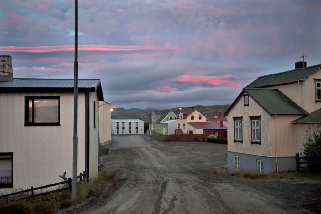 Stradina di paese con case colorate nel villaggio di Þingeyri al tramonto, Islanda nord-occidentale.

