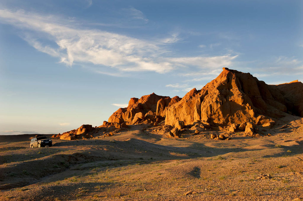 Scogliere infuocate di Bayanzag nel deserto del Gobi illuminate dalla luce del tramonto
