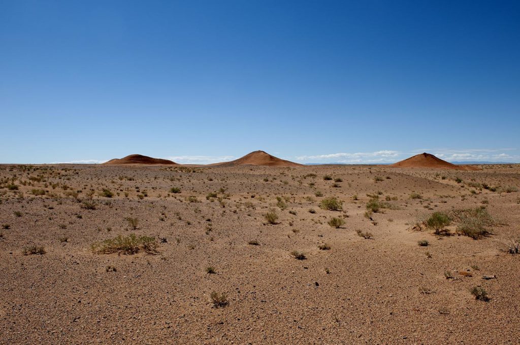 Paesaggio arido con dune basse nel deserto del Gobi sotto un cielo sereno

