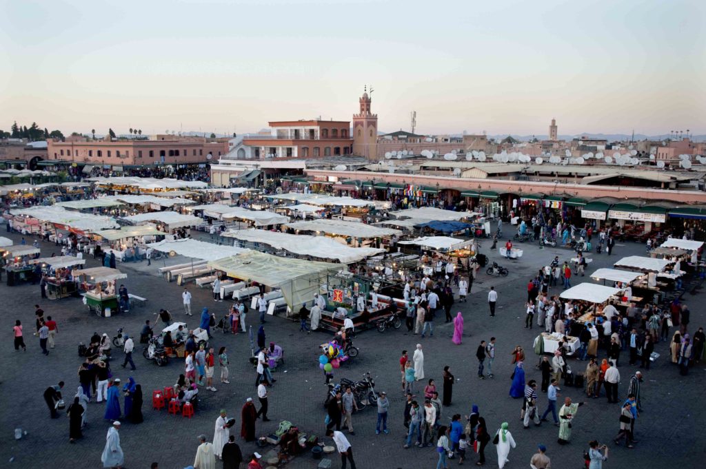 Vista panoramica su piazza Jemaa el-Fna a Marrakech con bancarelle e folla.