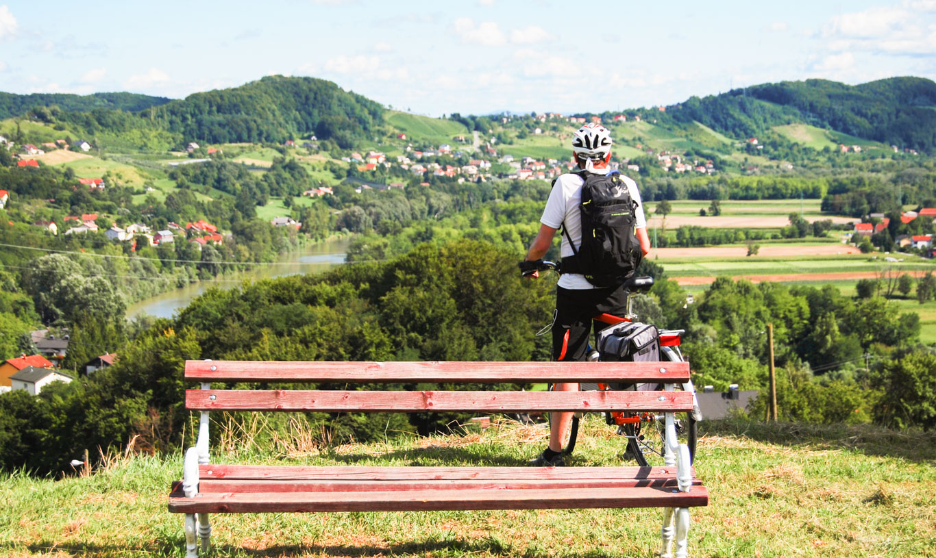 Ciclista che ammira un panorama collinare puntellato da casette