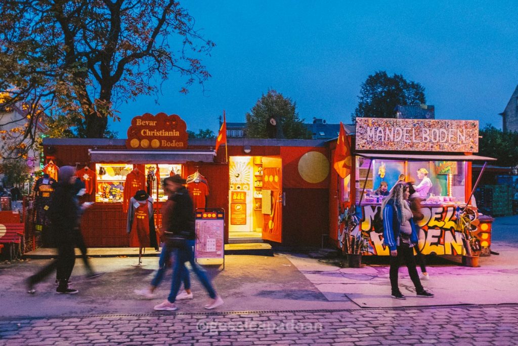 Ingresso del parco divertimenti Tivoli di Copenaghen illuminato di sera con visitatori.