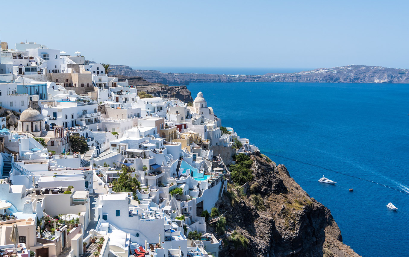 Santorini dall'alto: case bianche a sinistra e mare blu a destra