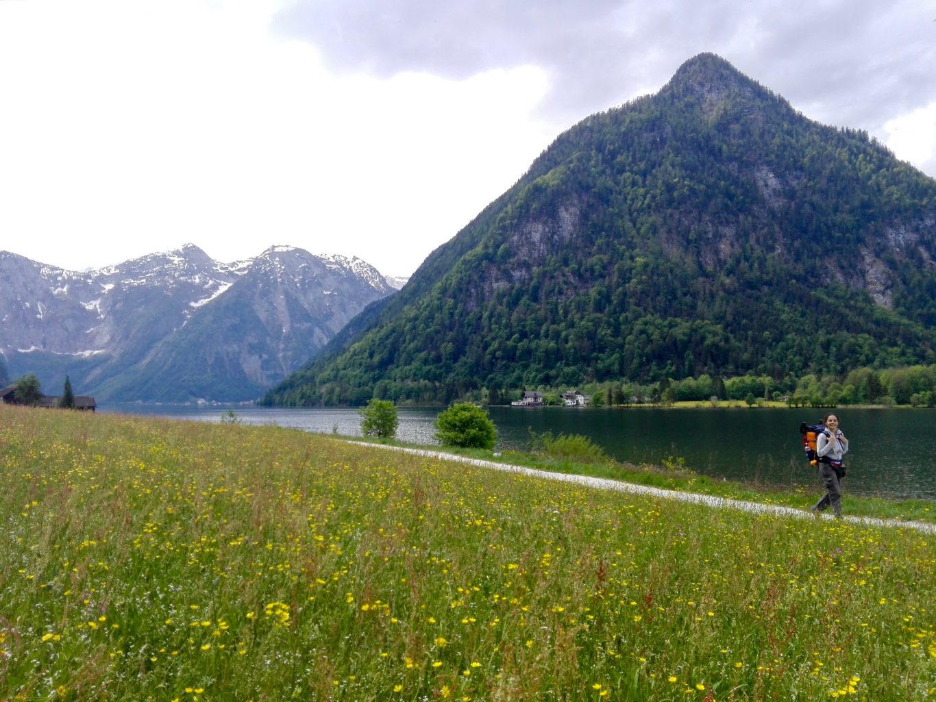 Donna in abiti sportivi cammina in un sentiero incorniciato da montagne