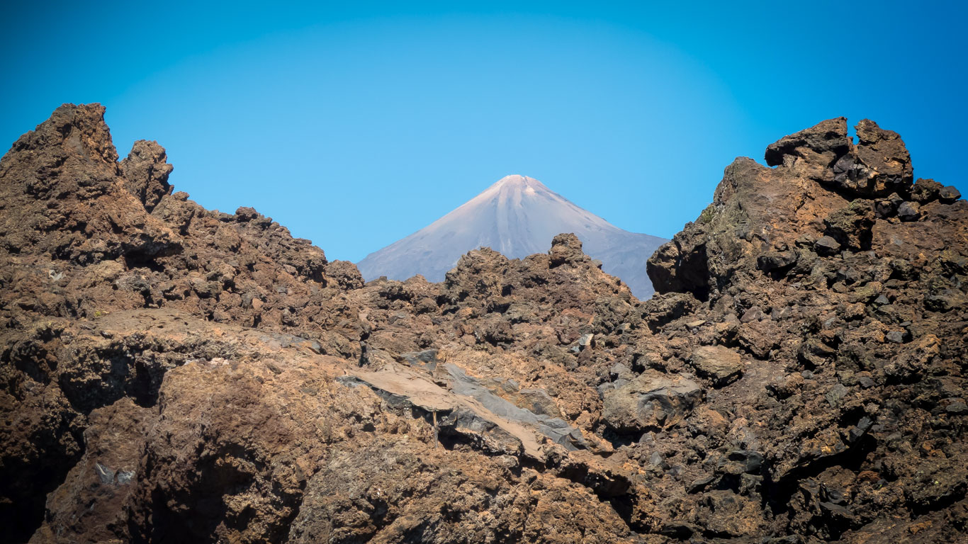 Vista su rocce e la cima del vulcano Teide sullo sfondo