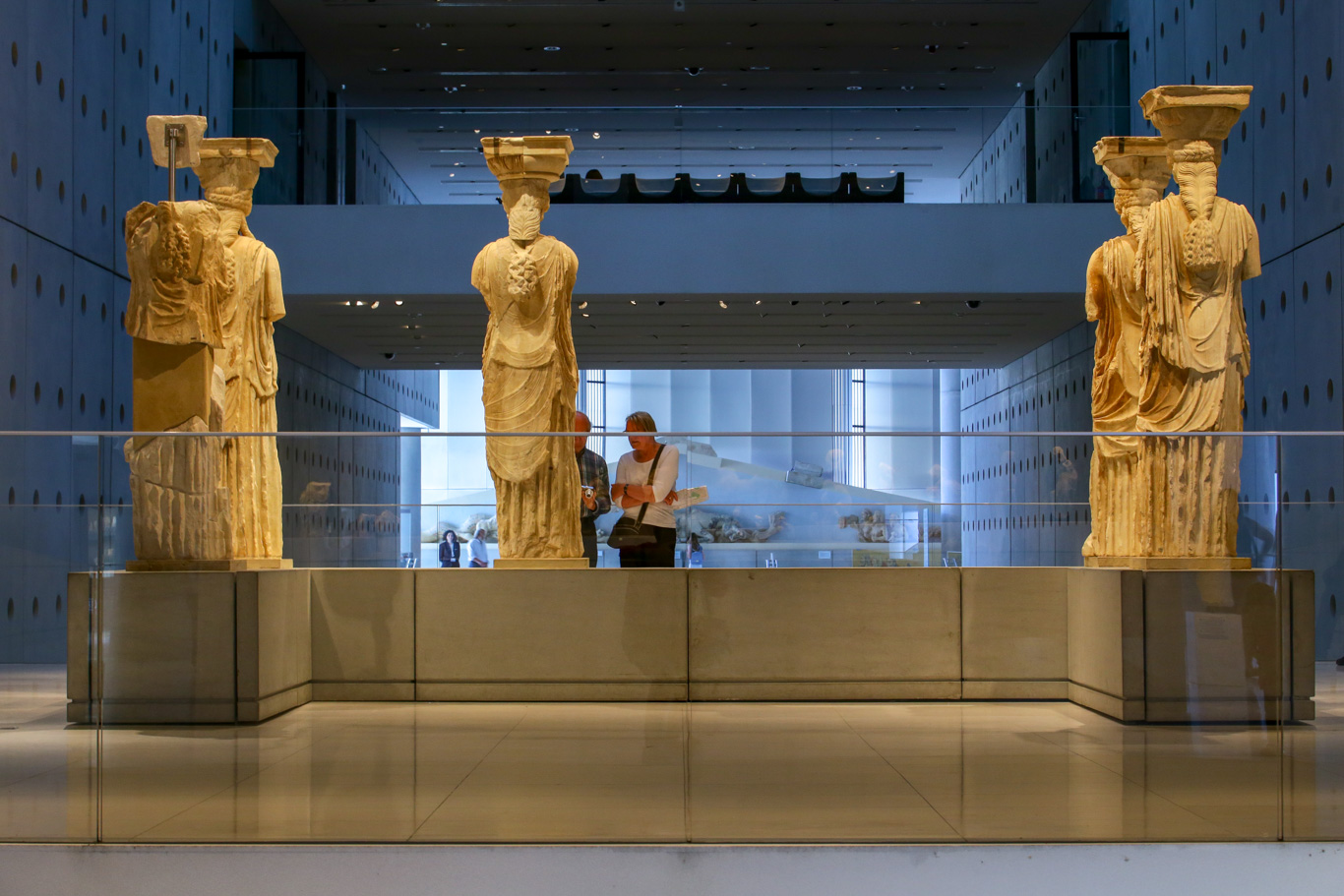 Statue antiche all'interno di un museo e due persone in ammirazione