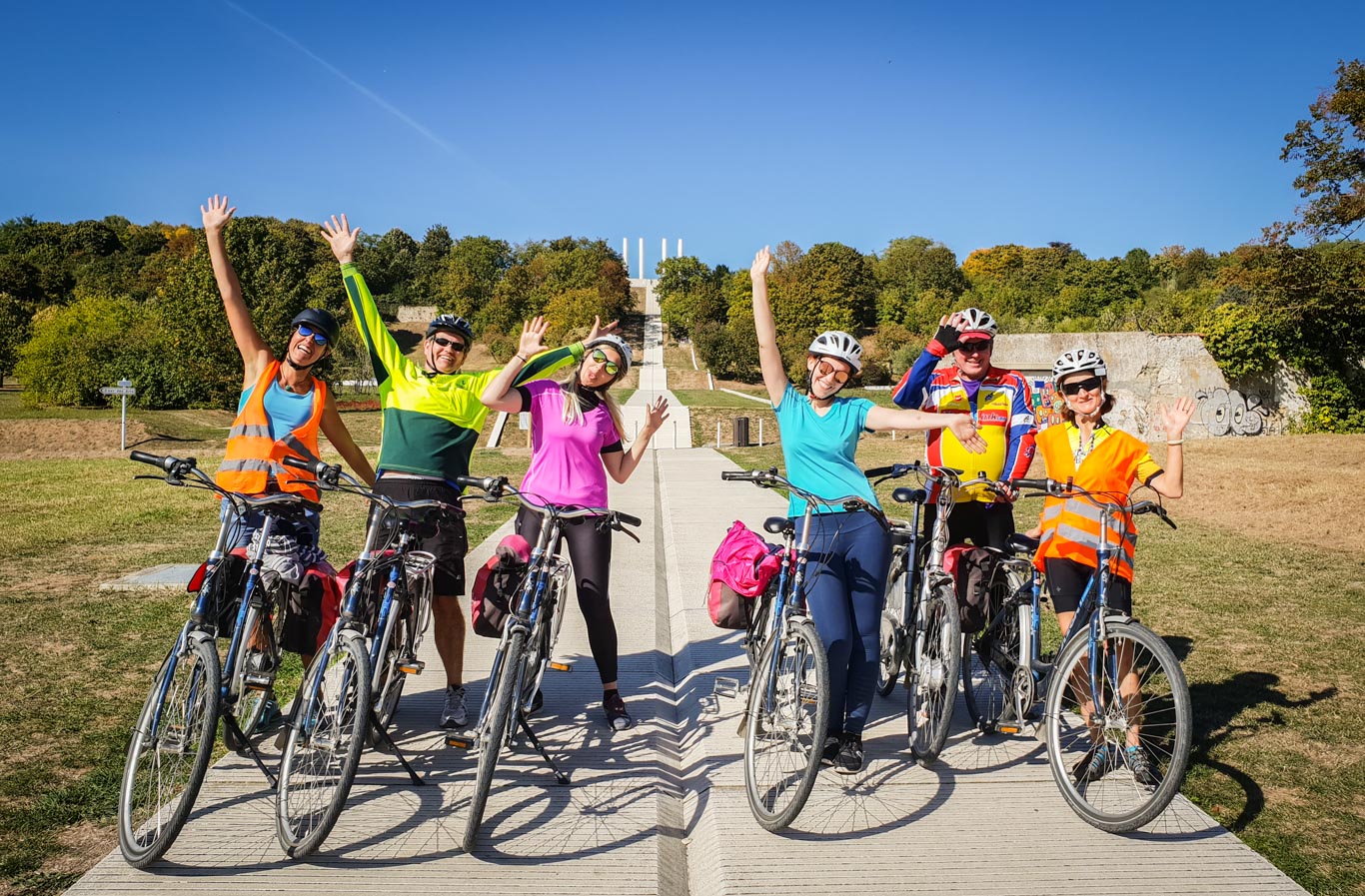 Gruppo di ciclisti fermi in pose buffe sorridono verso l'obiettivo