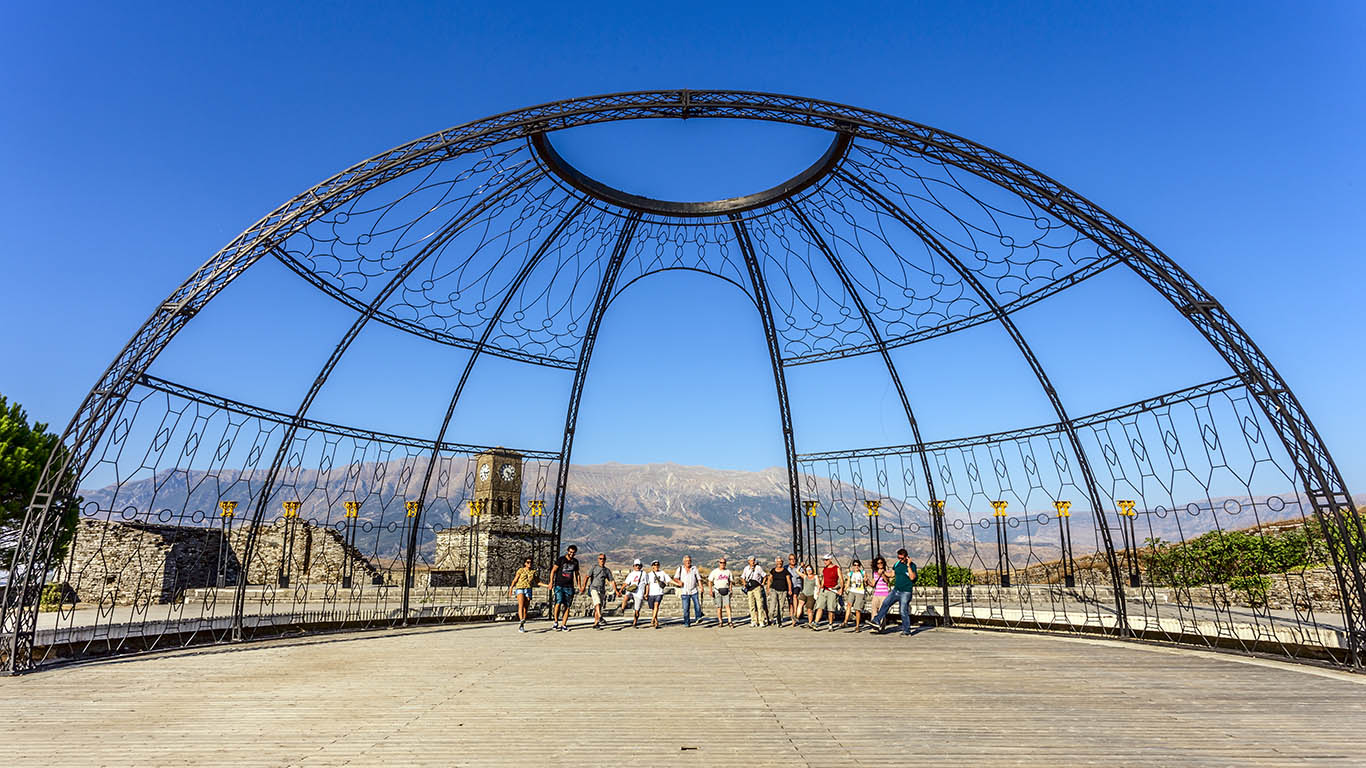 Gruppo di persone dentro ad una costruzione a cupola vicino alla Torre dell'orologio a Girocastro, Albania