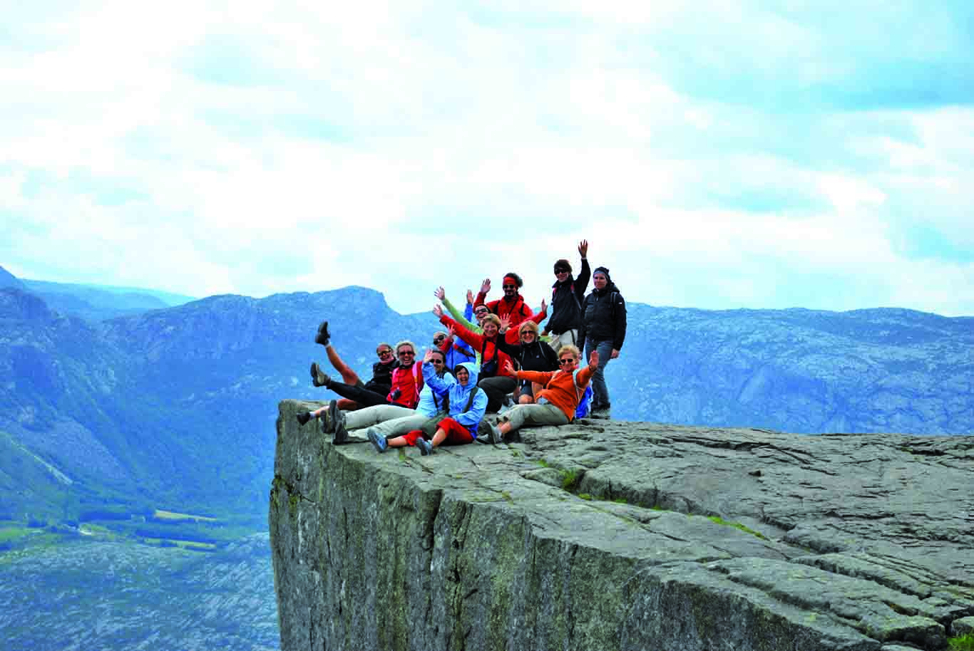 Gruppo di persone in posa sul Preikestolen, falesia di granito in Norvegia