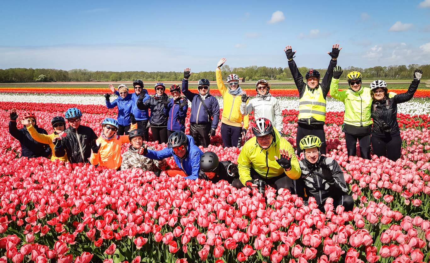 Gruppo di persone in viaggio per il tour dei tulipani con Girolibero saluta verso l'obiettivo 