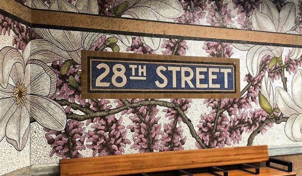 Particolare con mosaico di fiori rosa e scritta 28th street alla metropolitana di New York