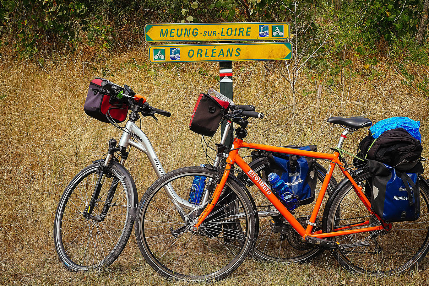 Two bicycles equipped with handlebar bags and side bags  