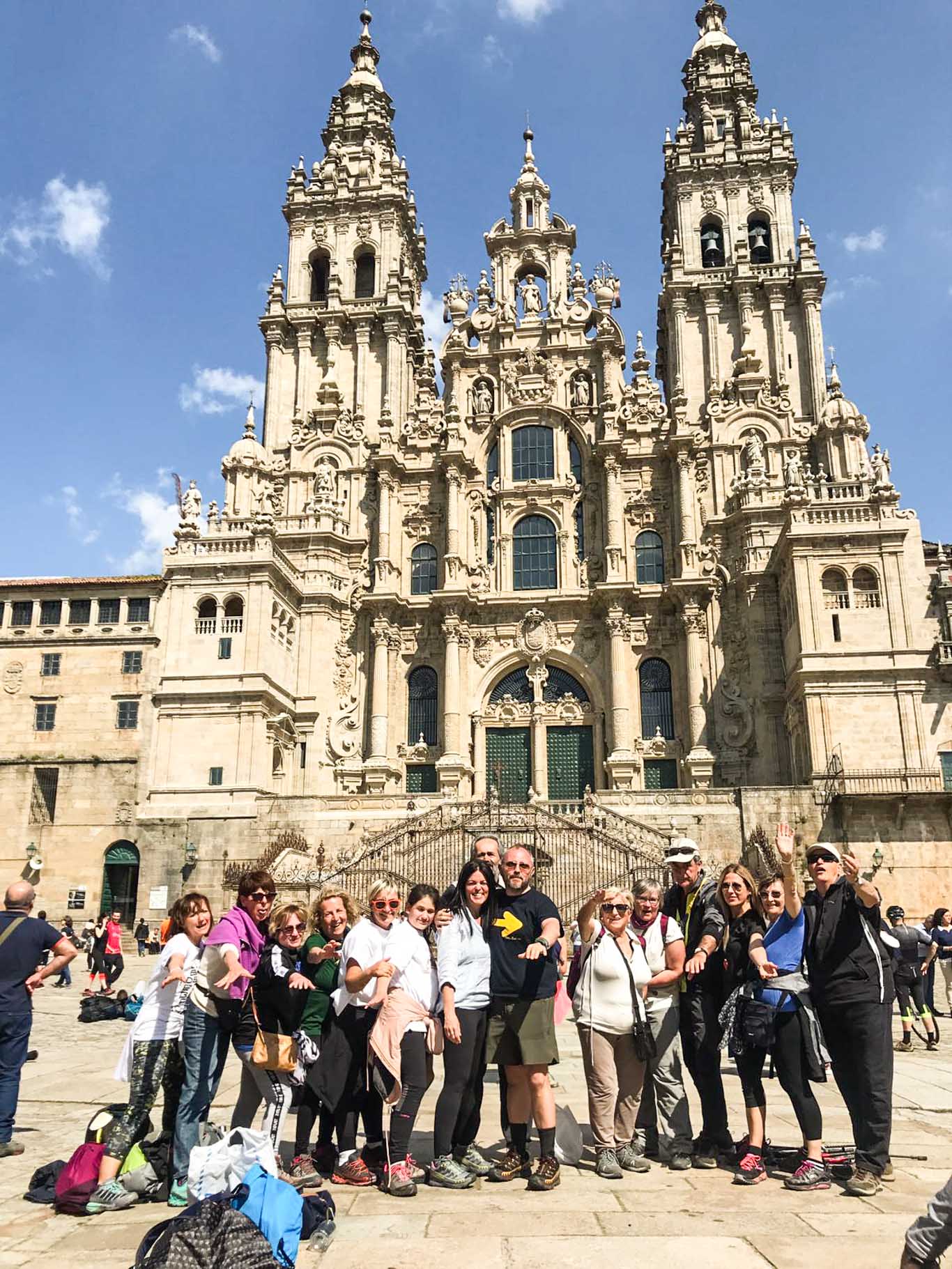 Gruppo di camminatori sorridenti di fronte alla cattedrale di Santiago. 