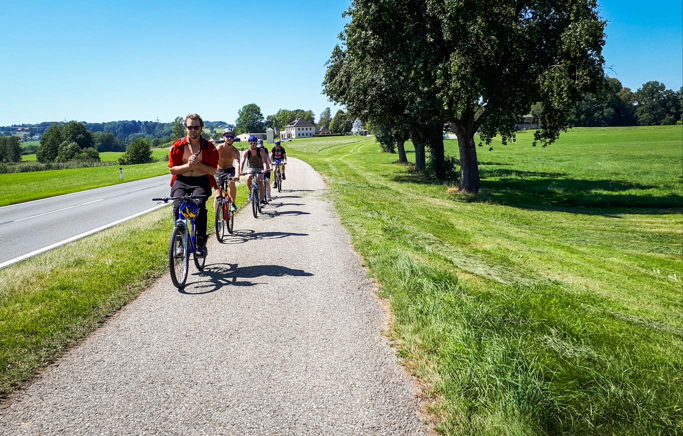 Ciclisti in viaggio con Girolibero pedalano lungo una ciclabile in mezzo alla natura nel salisburghese