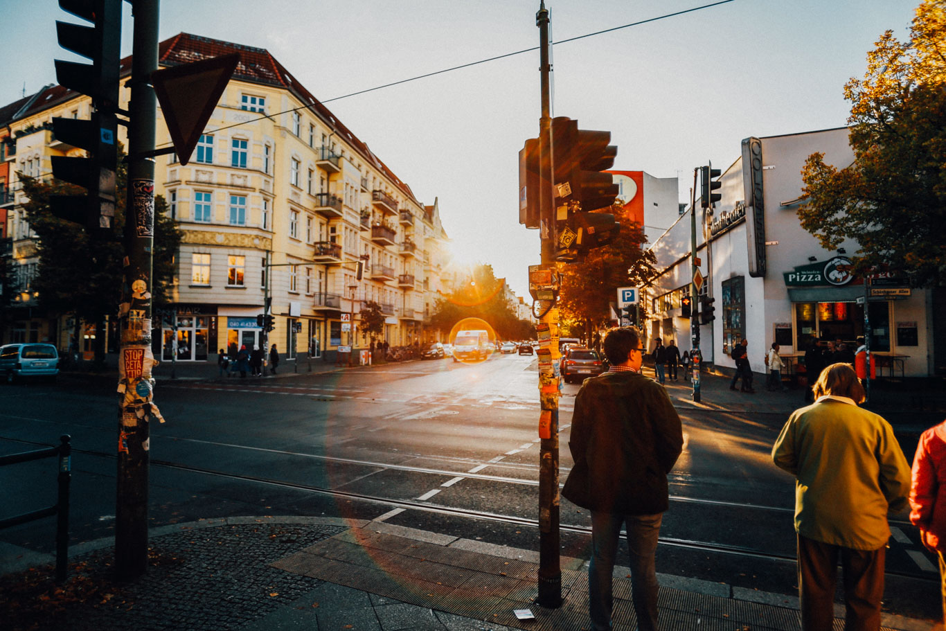 Immagine di vita quotidiana sulle strade di Prenzlauer Berg a Berlino: edifici e un incrocio con persone che aspettano il semaforo verde per attraversare la strada