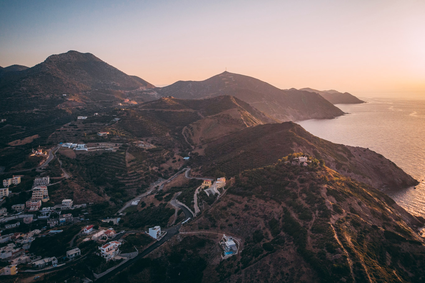 Imamgine dall'alto con montagne al calare del sole che si affacciano sul mare