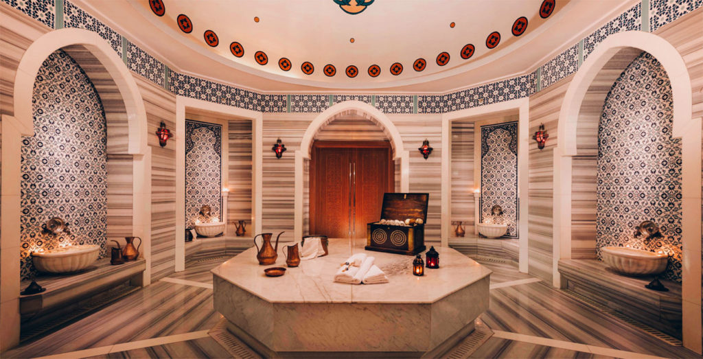 Hammam tradizionale marocchino con fontana centrale in marmo e piastrelle zellige, esperienza benessere a Marrakech