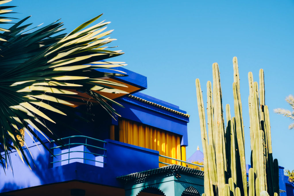 Facciata blu cobalto del Jardin Majorelle con palme e cactus, icona architettonica di Marrakech e Yves Saint Laurent