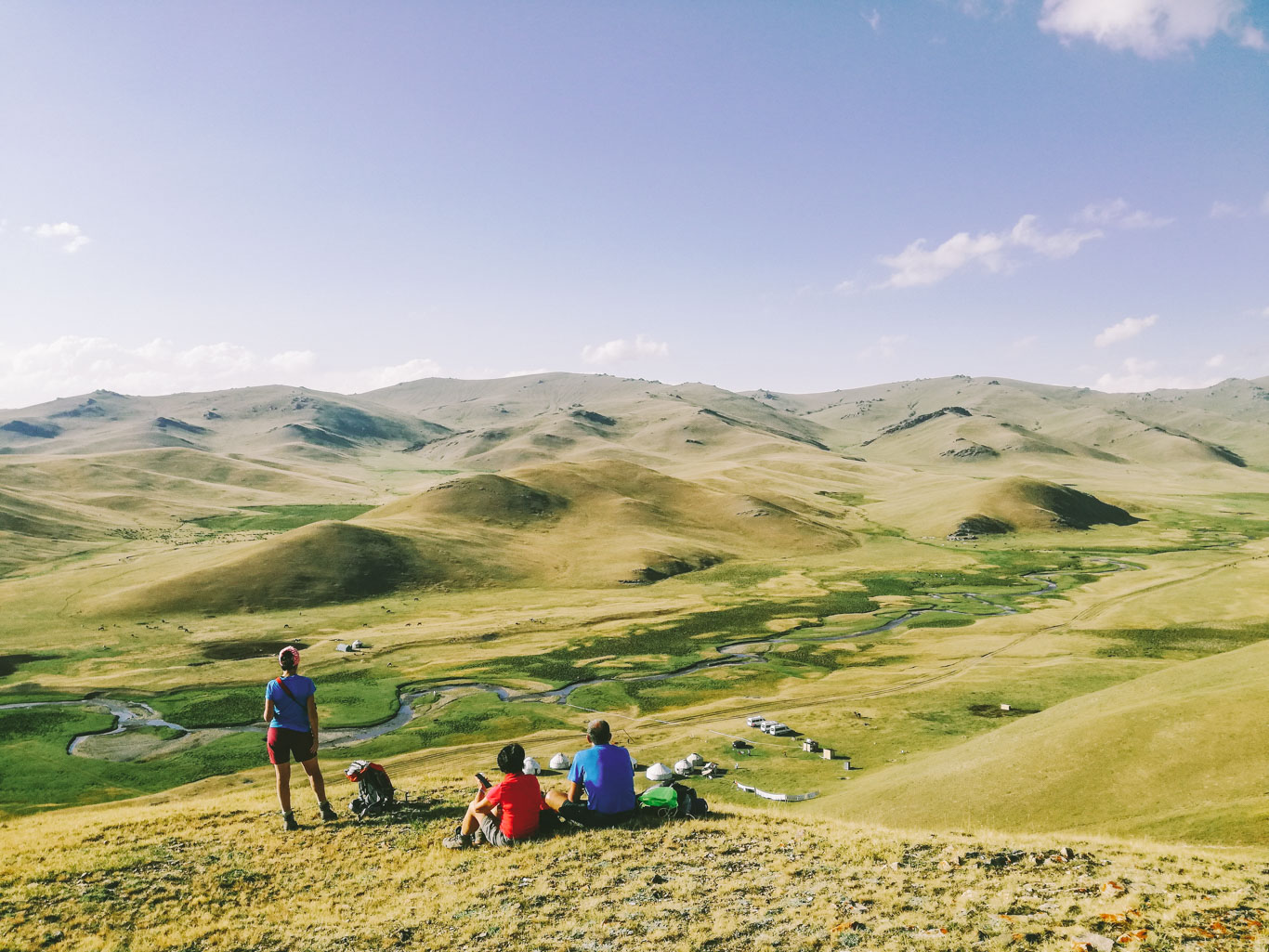Campeggio con yurte e viaggiatori su colline erbose, Kirghizistan