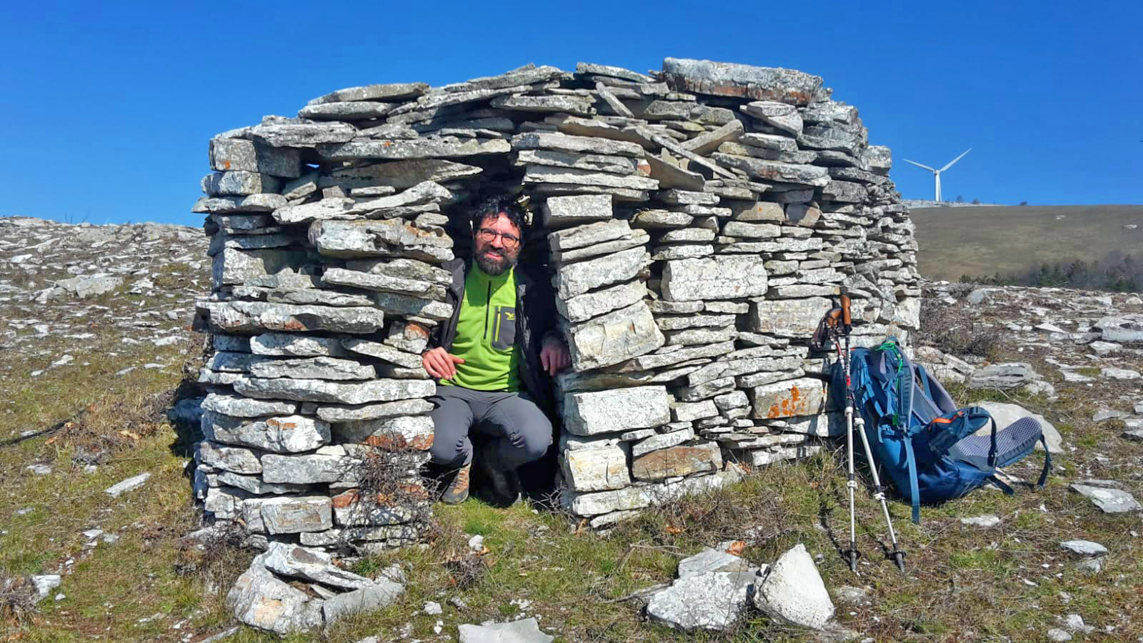 Uomo sorridente all'interno di una grotta fatta di pietre