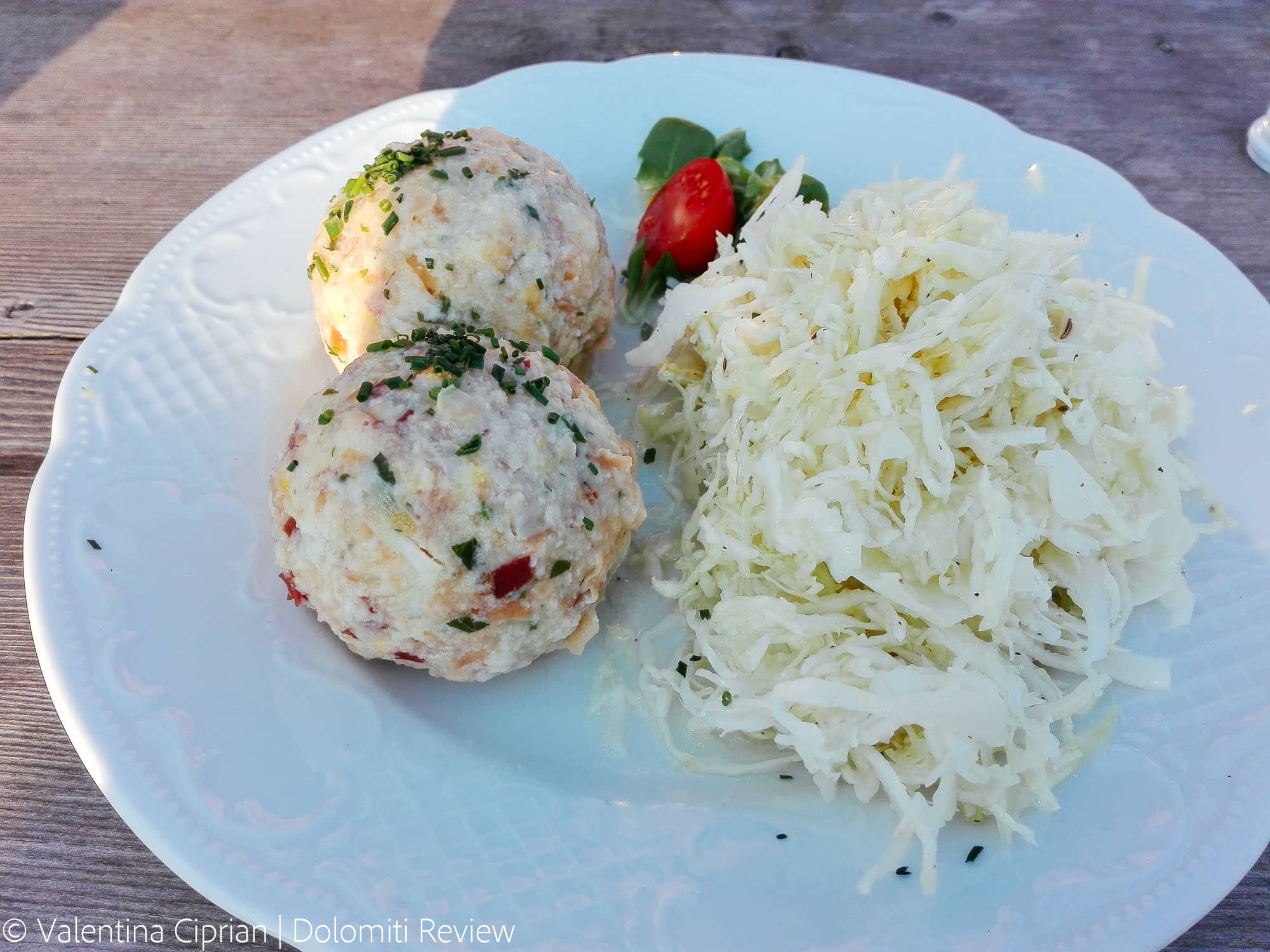 Typical dish of the Dolomites with two speck canaderli and stewed cabbage.