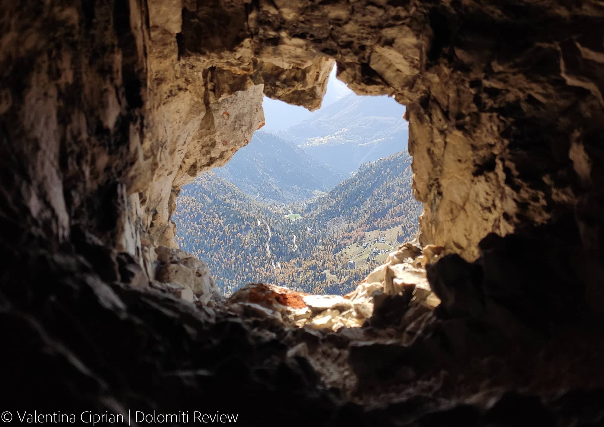 Mountain valley seen through the hole of a rock