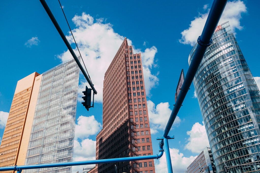 Parte alta di tre grattacieli con cielo azzurro sullo sfondo a Potsdamer Platz 