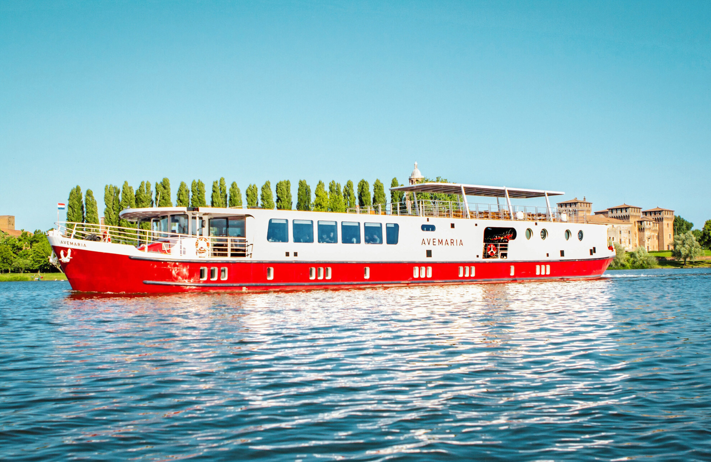 Red and white boat sailing in a river