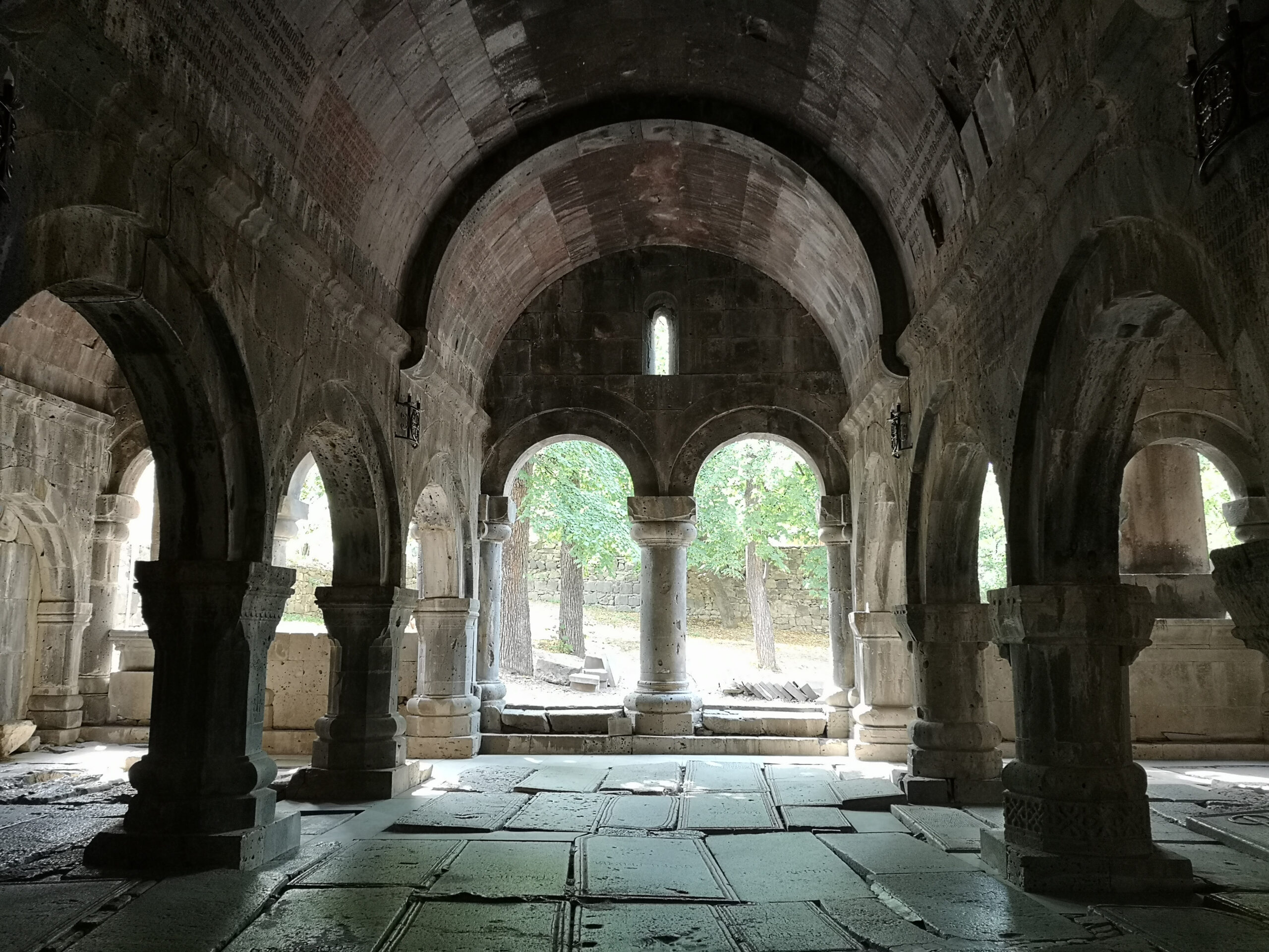 Interno spoglio di un antico monastero, con archi e colonne in pietra