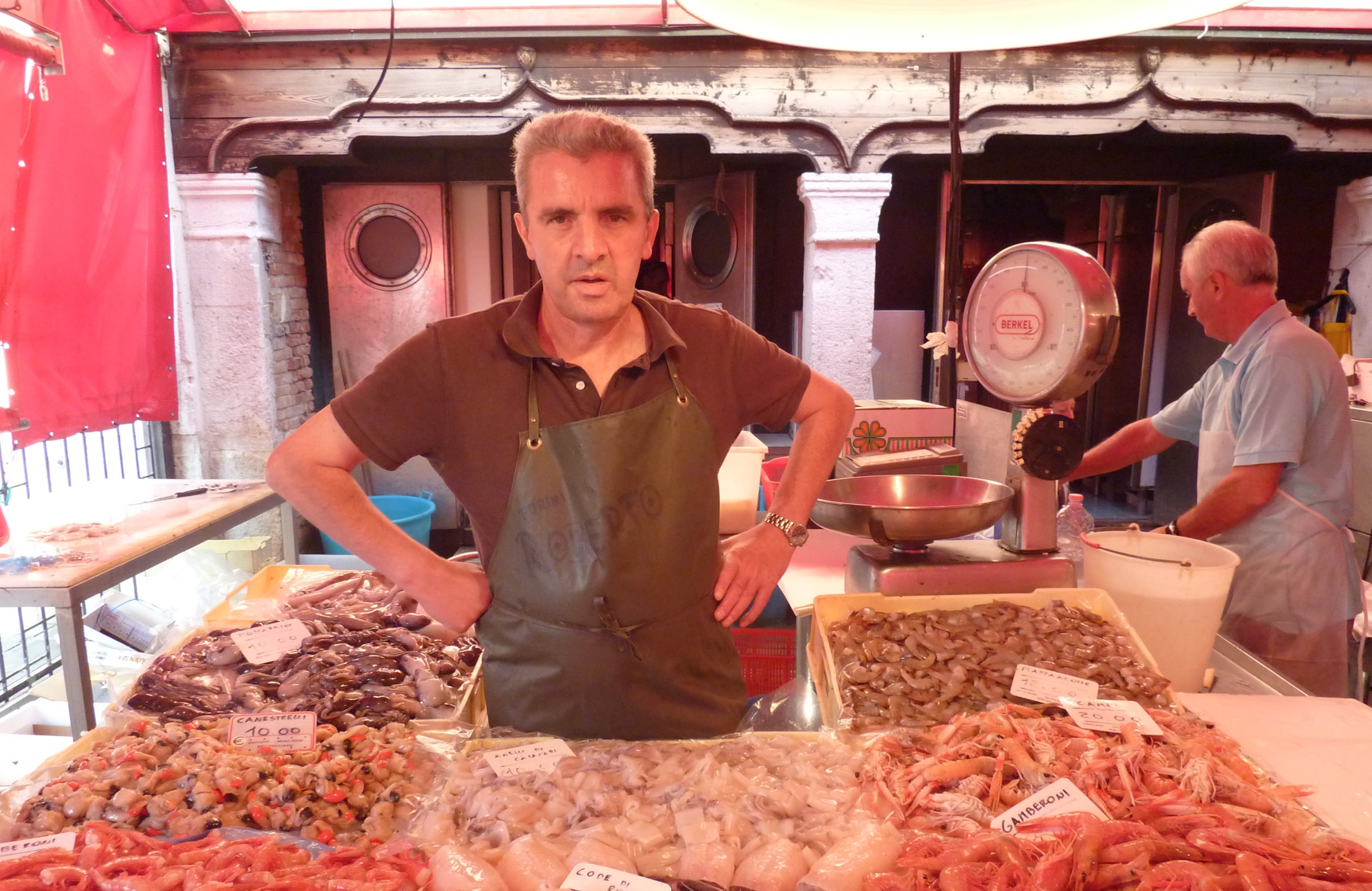 Vendor standing at a fish stall at the market