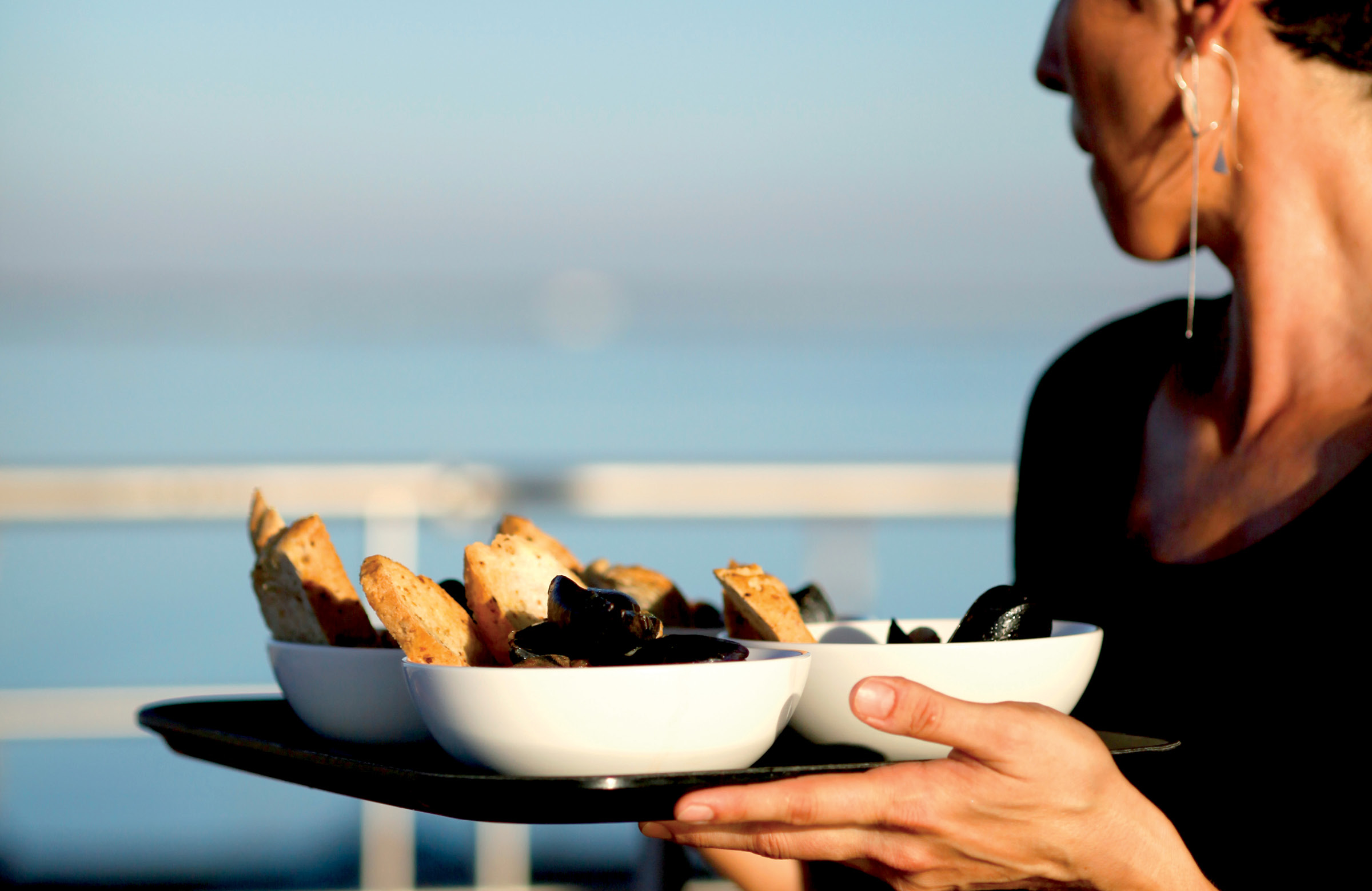 Woman carrying a tray with bowls of food