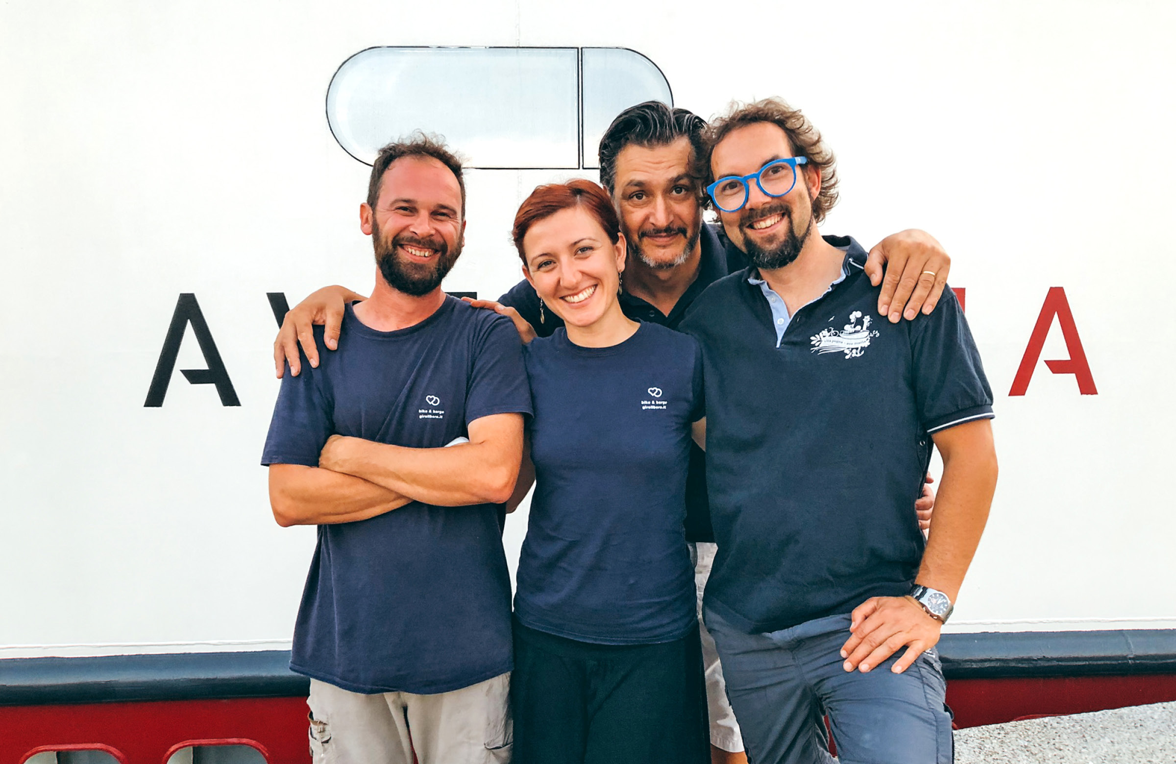 People standing in front of a boat smiling  