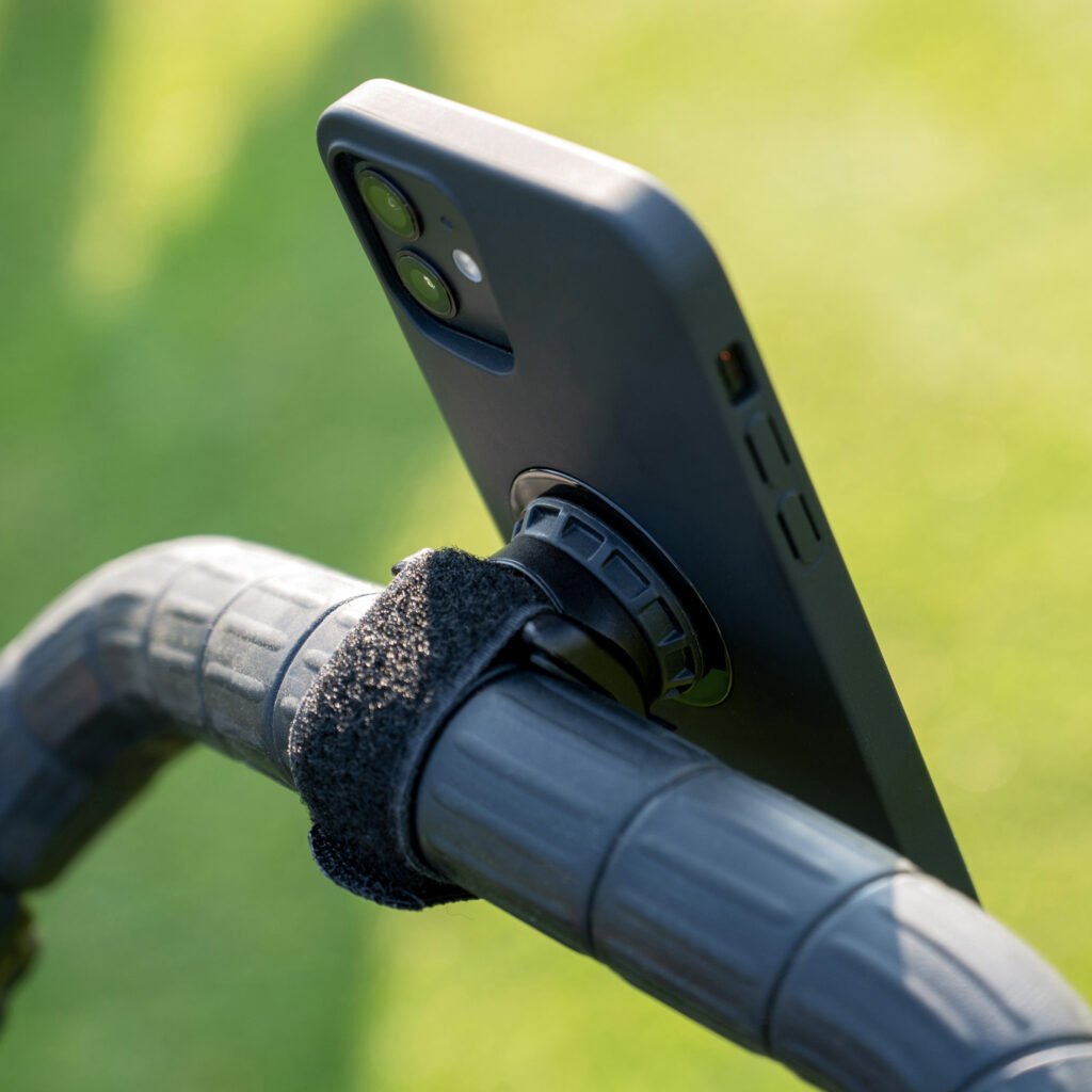 Detail of an attached cell phone with holder on a bicycle handlebar.