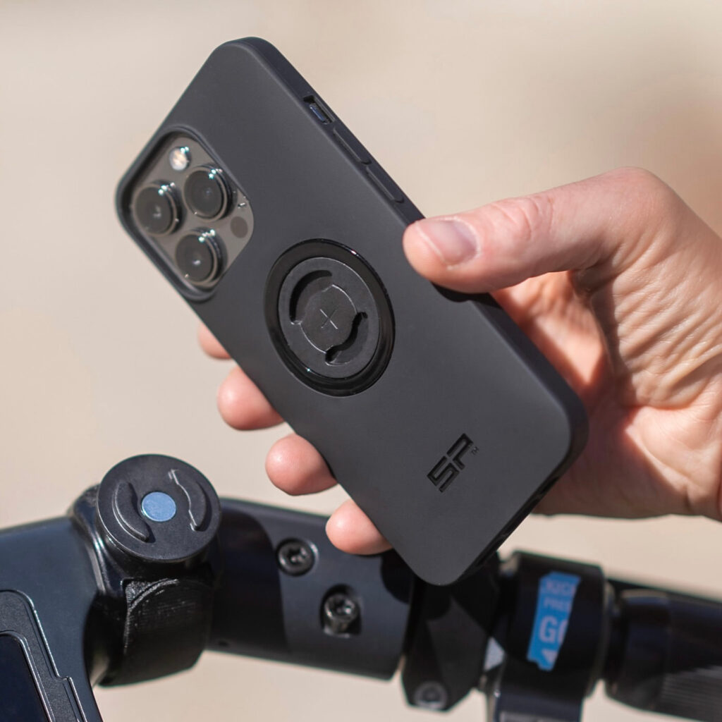 Hand about to attach a cell phone to a bike mount.