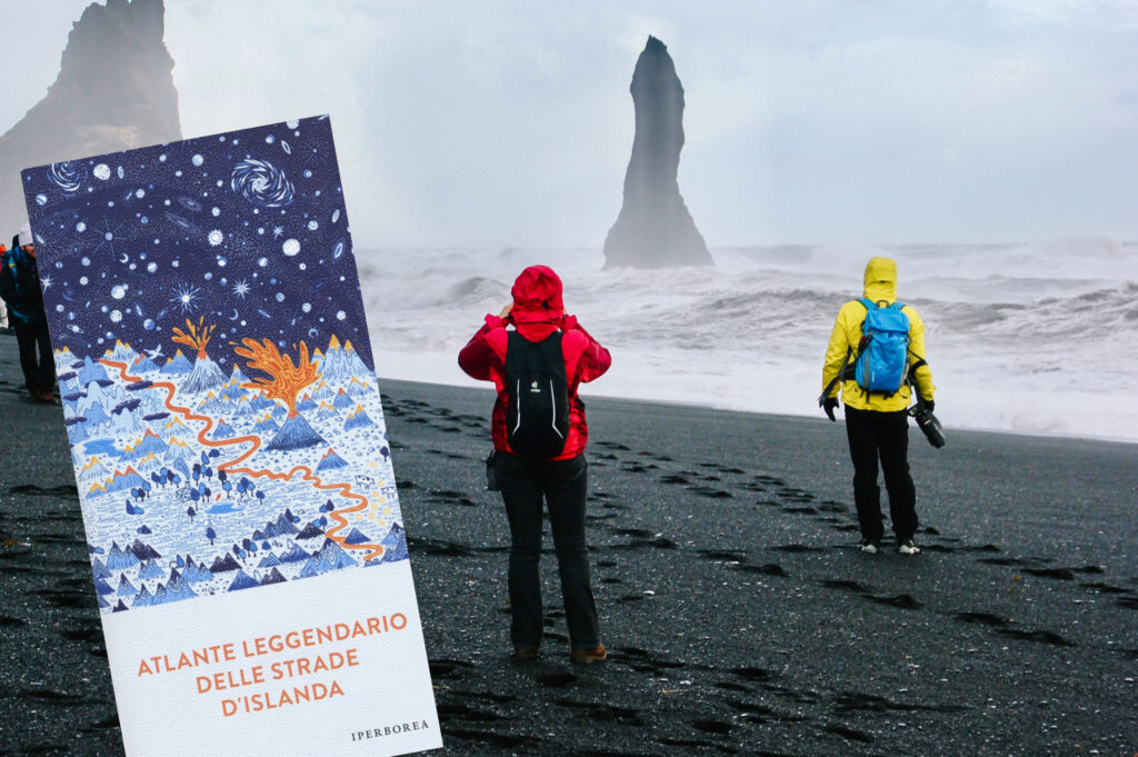 Libro Atlante leggendario delle strade d'Islanda - Iperborea e sullo sfondo due turisti con giacche colorate nella spiaggia nera in Islanda