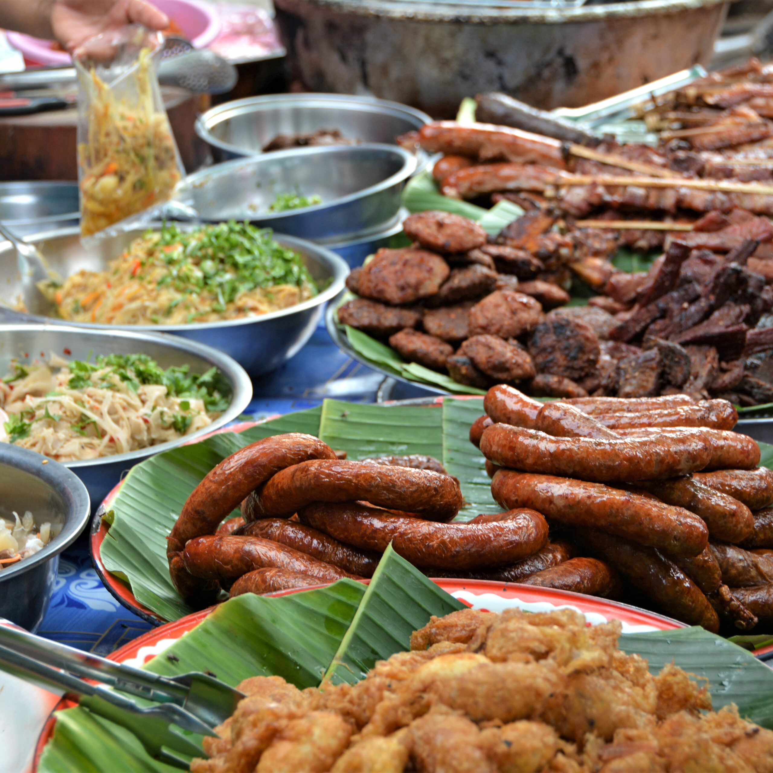 Bancarella di street food nel mercato notturno di Vientiane, Laos, con salsicce sai oua e carni grigliate tradizionali