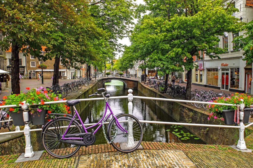 Amsterdam canal with bicycles and flowers, a symbol of the Netherlands.