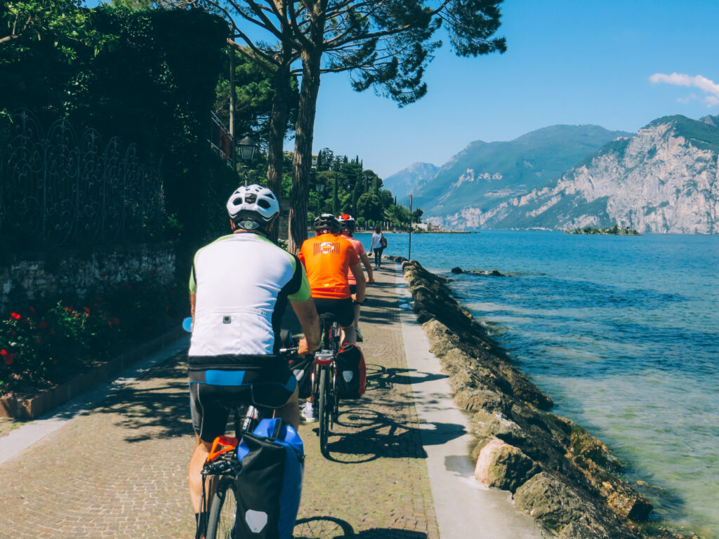 Cyclists riding along the shore of Lake Garda, northern Italy