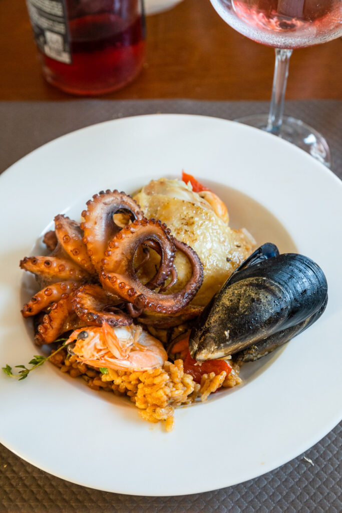 Seafood dish with octopus, mussels and rice served with rosé wine, traditional Provençal cuisine