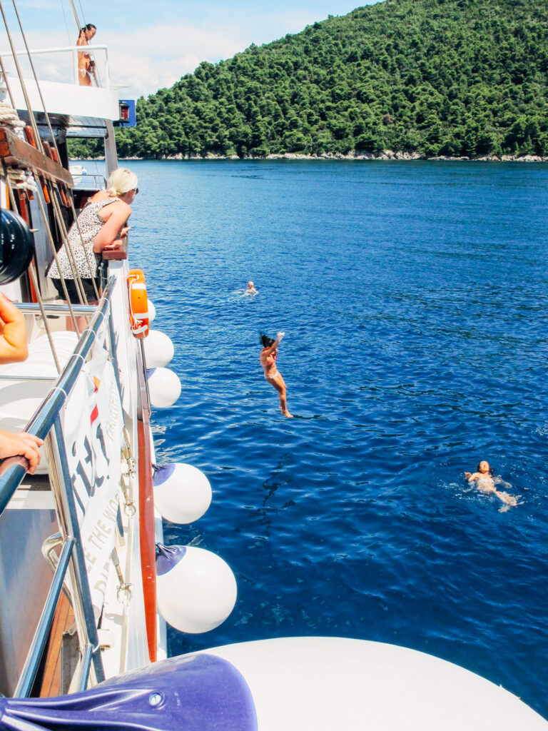 Traveller diving from a boat deck into the blue Adriatic Sea, Croatia cycling and sailing holiday
