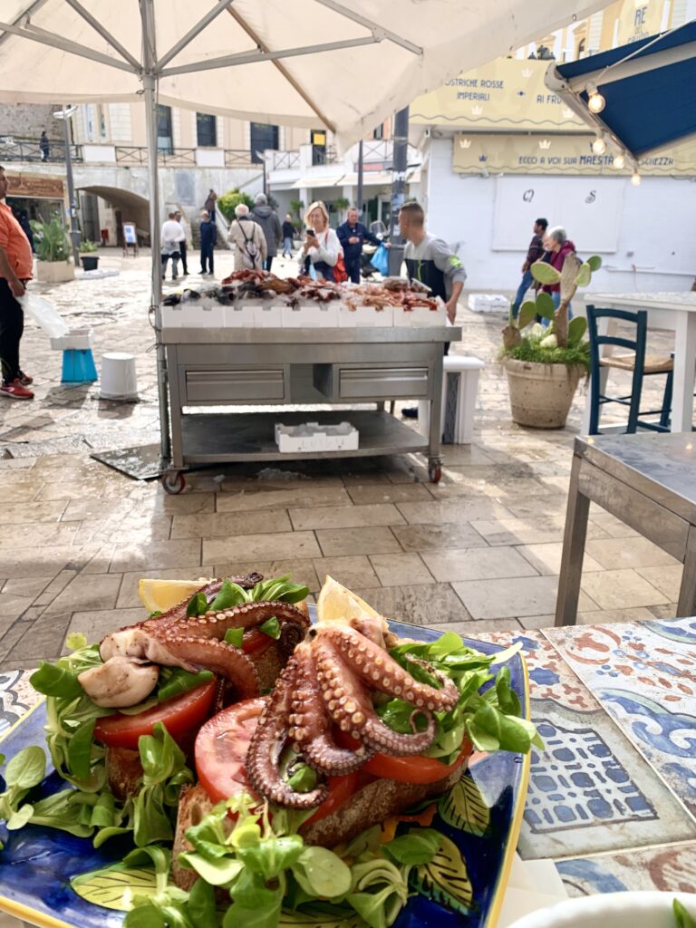 Grilled octopus salad near a fish market in Salento